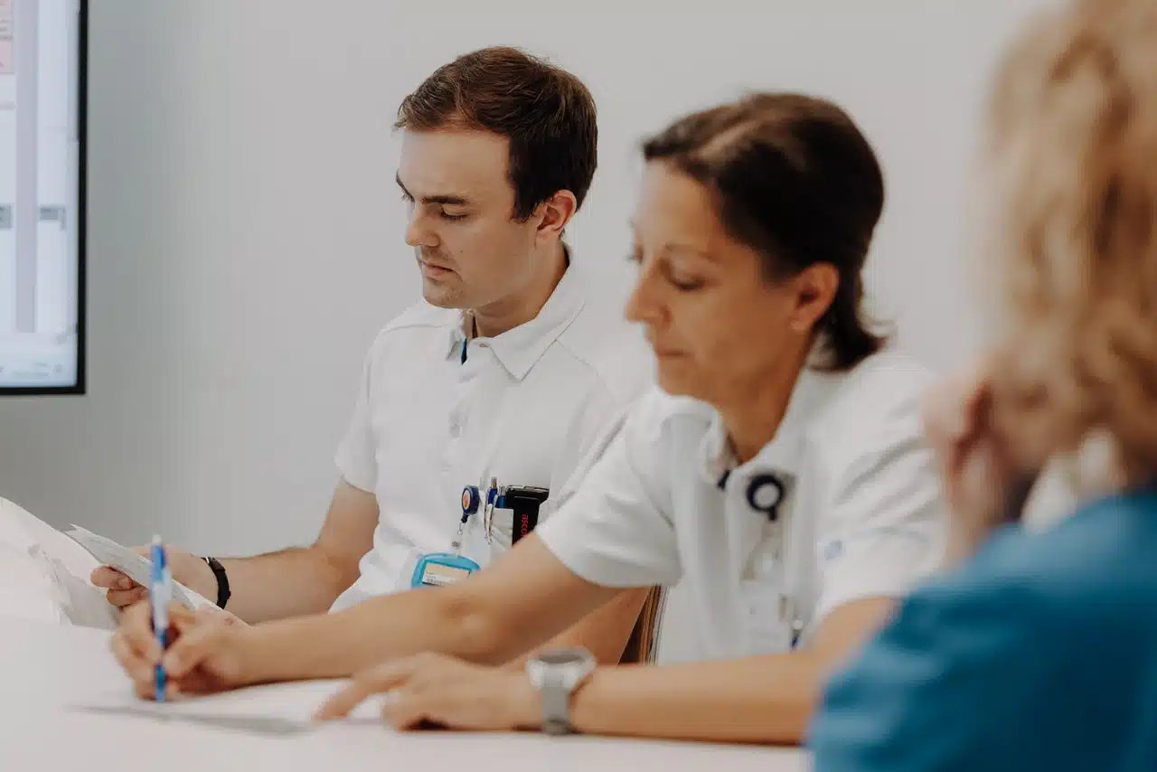 Ärzteteam bei der Besprechung mit einer Patientin in der Schmerzmedizin
